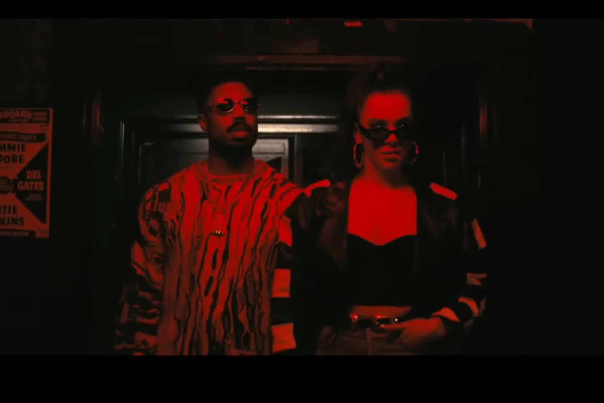 Due afroamericani entrano in un locale, il tono rosso nella foto prevale su tutto e loro sono solo due ombre nel rosso carminio. È una scena del film Sinners