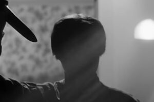 Una figura nell'ombra con un coltello in mano la scena della doccia di Psycho