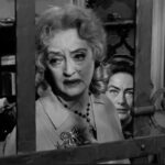Bette Davis (in primo piano) Joan Crawford dietro di lei alla finestra in una scena di 'Che fine ha fatto Baby Jane'