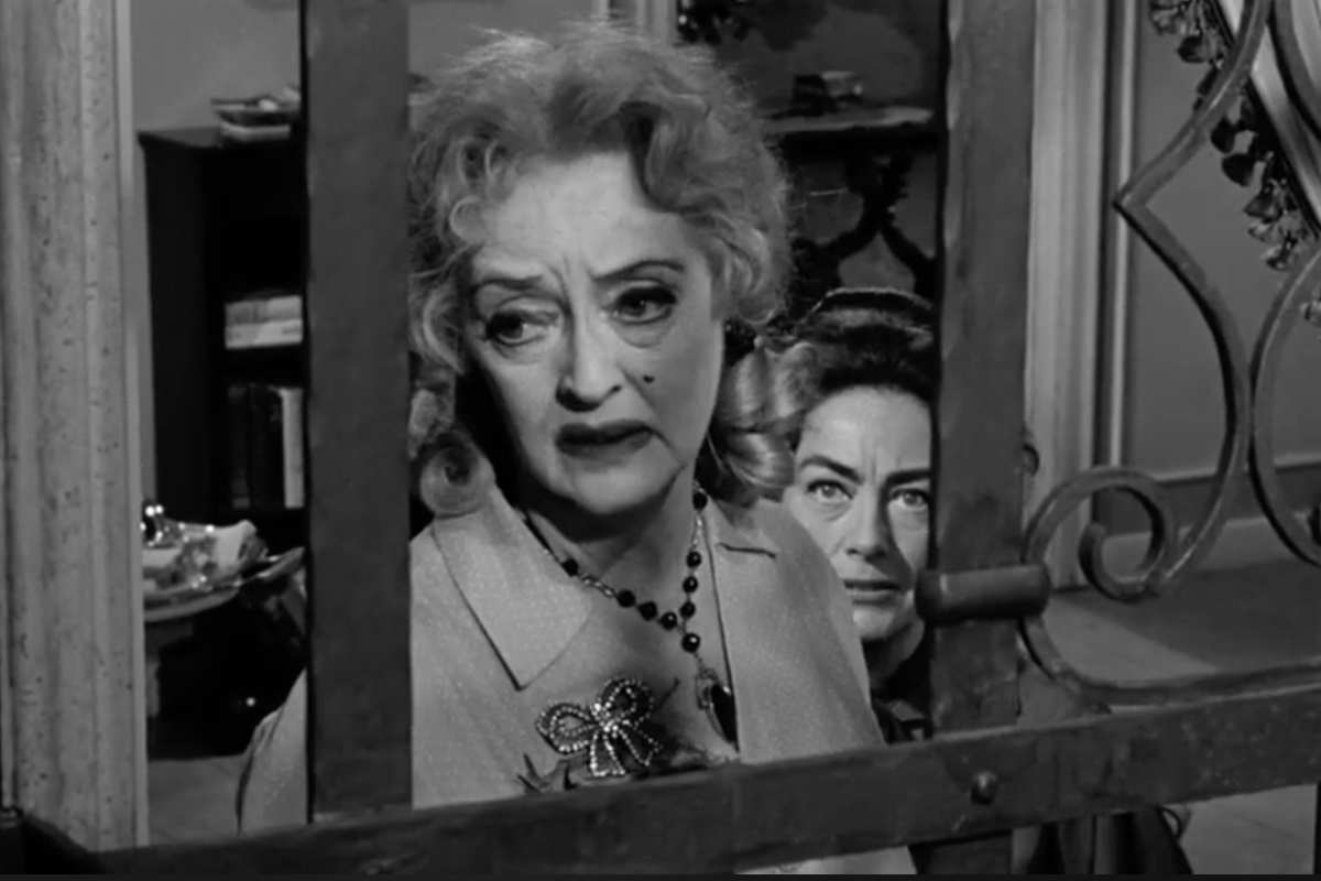 Bette Davis (in primo piano) Joan Crawford dietro di lei alla finestra in una scena di 'Che fine ha fatto Baby Jane'