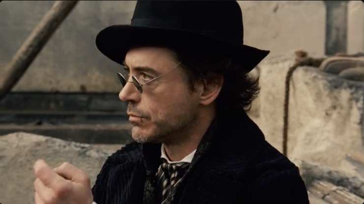 Robert Downey Jr con cappello occhiali da sole, di profilo sul set di Sherlock Holmes