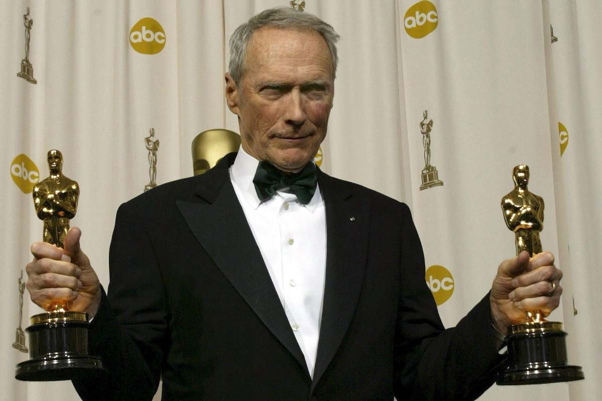 Clint Eastwood con in mano due premi Oscar