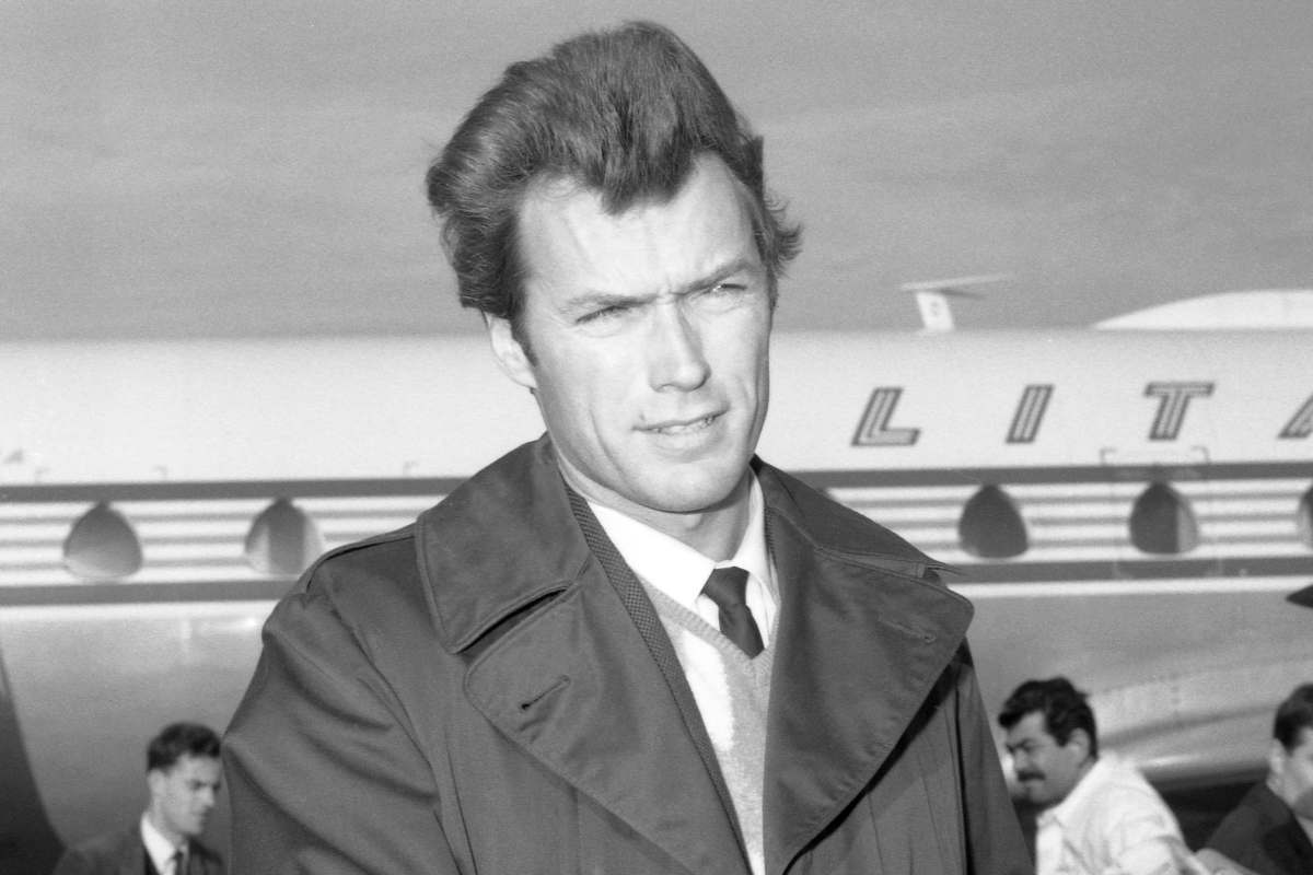 Clint Eastwood in bianco e nero dietro di lui un aereo 
