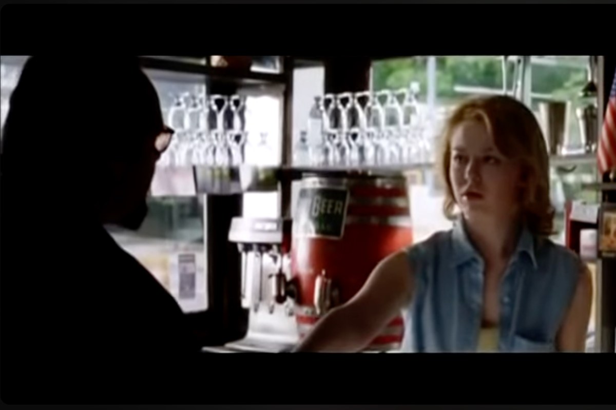 L'ombra di Jack Nicholson mentre fa uno scambio di denaro con una giovane donna dietro ad un bancone in una scena del film The Departed