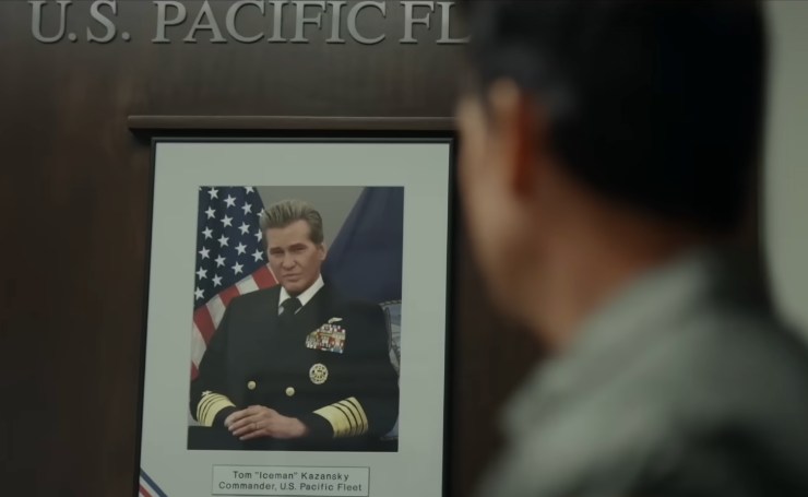 Tom Cruise di spalle di fronte una foto di Val Kilmer