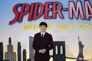 Tom Holland e sullo sfondo il poster di Spider Man Brand New Day
