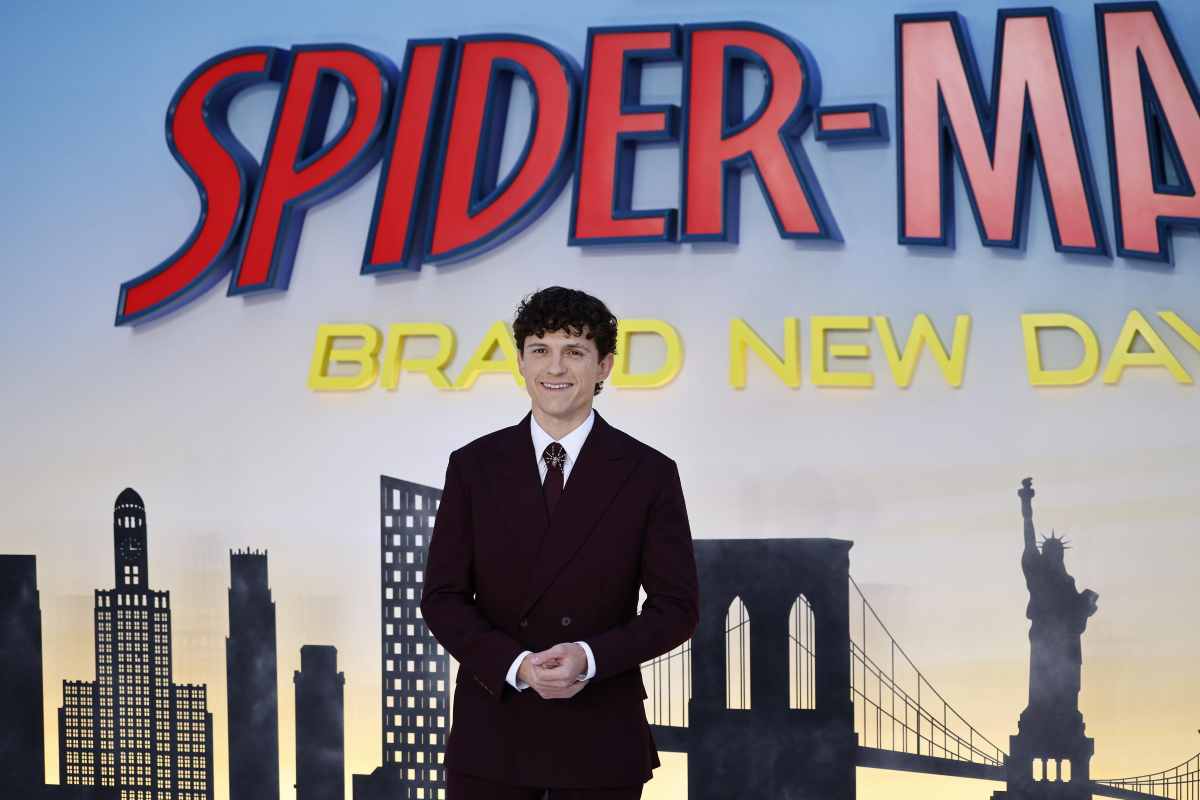 Tom Holland e sullo sfondo il poster di Spider Man Brand New Day