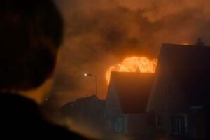 L'esplosione su Lockerbie, il cielo incendiato, sullo sfondo delle case