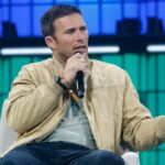 Scott Eastwood con il microfono in mano mentre parla